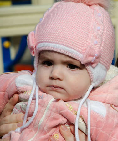 Portrait of a little child in a pink suit on the playground and in the park in the afternoonの写真素材