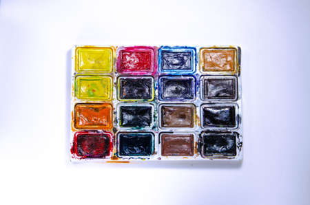 Palette with watercolors and brushes for paints on a white background. Watercolor paints. Brushes. Top and front viewの写真素材
