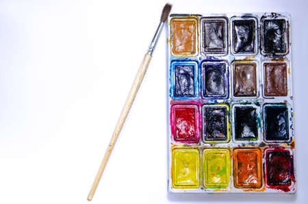 Palette with watercolors and brushes for paints on a white background. Watercolor paints. Brushes. Top and front viewの写真素材