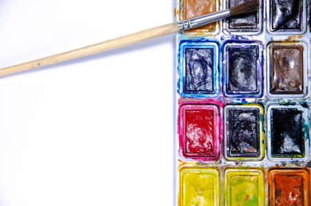 Palette with watercolors and brushes for paints on a white background. Watercolor paints. Brushes. Top and front viewの写真素材