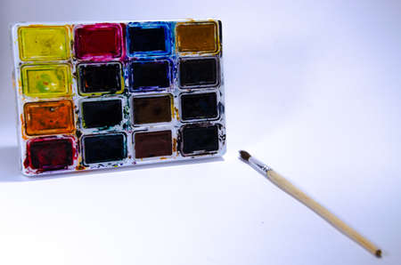 Palette with watercolors and brushes for paints on a white background. Watercolor paints. Brushes. Top and front viewの写真素材
