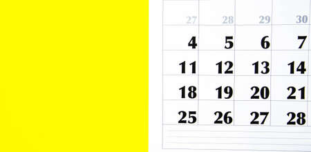 Macro calendar from different angles on a yellow and pink background. Black and red numbers on the...