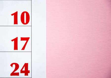 Macro calendar from different angles on a yellow and pink background. Black and red numbers on the...