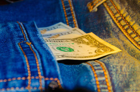 American banknotes in jeans pocket. A note in denominations of $ 100 peeps, stick out from the back, the foremost pants pocket. Money falls out of pocket. Flare effect. View from different anglesの写真素材