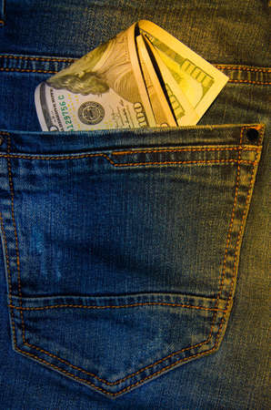 American banknotes in jeans pocket. A note in denominations of $ 100 peeps, stick out from the back,...