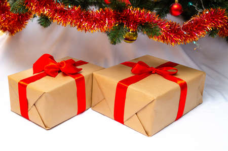 Boxes with gifts on a light, blue background and under the Christmas tree. Gift in the hand....