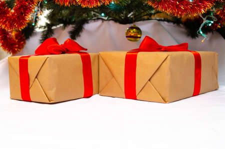 Boxes with gifts on a light, blue background and under the Christmas tree. Gift in the hand. Christmas presents, Nicholas Day, Valentine's Day. Bright boxes with bright ribbons. Gifts in Macroの写真素材