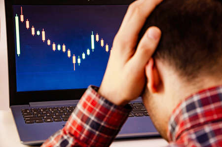 Trading on the exchange. A man is holding his head. Losing rates, promotions. Win, lose. Good luck...