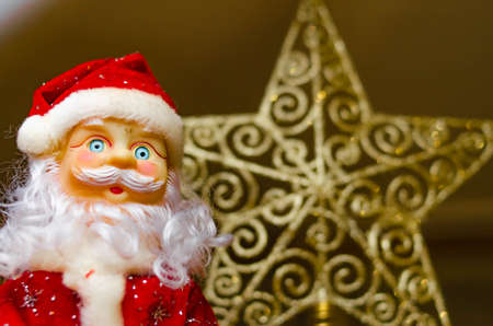 Toy Santa Claus, on the background of the New Year tree, and on the background of the New Year star on the Christmas tree. Toy Santa in close-up. Christmas decoration. Celebrationの写真素材