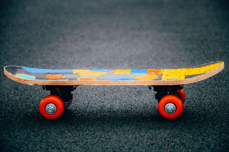 Skateboard on a black background with bright red wheels. Skate side and angle. Skateboard for children and adults. Sport. Skateboard on the pavementの写真素材