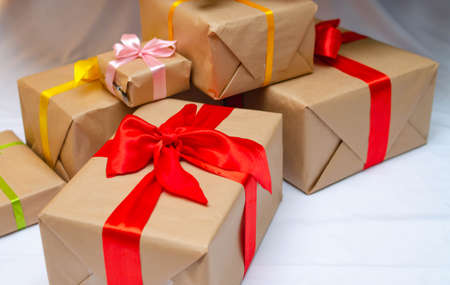 Boxes with gifts on a light, blue background and under the Christmas tree. Gift in the hand....