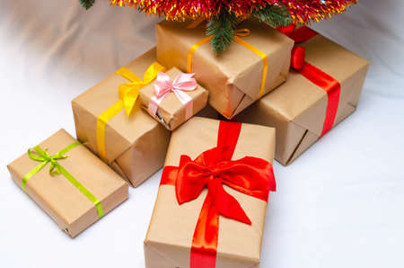 Boxes with gifts on a light, blue background and under the Christmas tree. Gift in the hand....