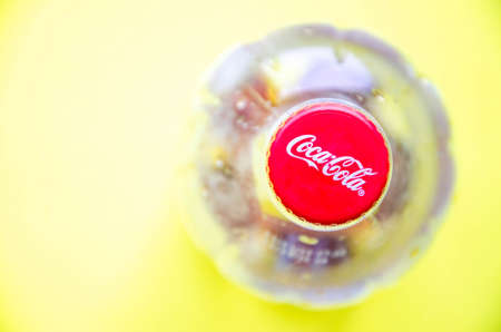 March 2020. Kramatorsk, Ukraine. 1 liter Coca-Cola empty plastic bottle. Top view. Coca cola cap in close-up on blue and yellow background.  copy spaceのeditorial素材