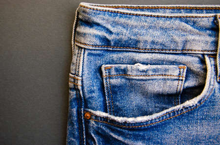 Jeans on a black background. Jeans elements, pockets, seams in close-up. Ripped jeans. Copy Spaceの写真素材