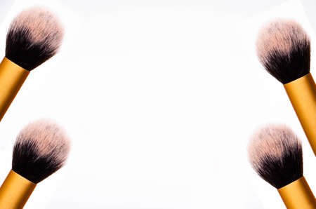 Large fluffy makeup brush with gold pen and black edge. The tips of the upper part of the brush on the right and left symmetrically on two brushes on both sides. In the middle is a place for text.の写真素材