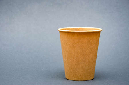 Brown paper cup for coffee, tea, a drink from environmental materials on a black background. A small cup in macro is on the right. Front view and top view, bottom visible. Place for text on the leftの写真素材