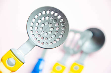 Toy tool for cooking. Ladle, slotted spoon, spatula for cooking on a yellow, blue, black background. Kitchen tools. Copy Spaceの写真素材