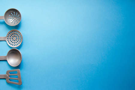 Toy tool for cooking. Ladle, slotted spoon, spatula for cooking on a yellow, blue, black background. Kitchen tools. Copy Spaceの写真素材