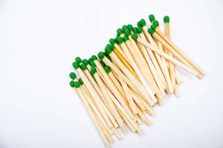 Wooden little matches with a green head. A bunch of matches are on the right. Left place for text. Macroの写真素材