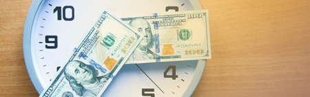 Analog clock and dollars on a wooden table. The inscription YOU ARE READY? Dollars in the form of a shooter. View from different sides.の写真素材
