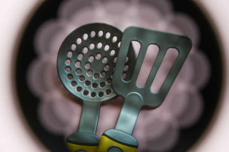 Toy tool for cooking. Ladle, slotted spoon, spatula for cooking on a yellow, blue, black background....