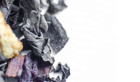 Black tea with bergamot and citrus leaves on a white background. Loose tea in a heap. Tea in a very...