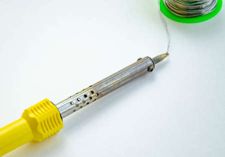 Soldering iron, tin, rosin on a yellow background. Macro. Repair of electrical equipment, radio...