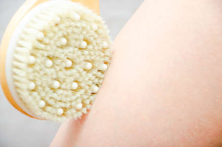 Dry massage. Massage at home, in the salon with a brush of natural bristles. Girl does massage legs,...