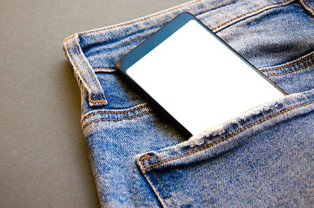 White screen smartphone in jeans pocket. Smartphone place for text. Smartphone in a pocket on a...