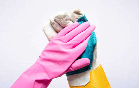 Pink rubber glove for cleaning with the palm up and next to the construction glove with the palm up...