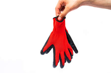 Gloves for workers, construction red with black rubber coating. Black-red gloves. Hand holds, throws out gloves on a white background. Used glovesの写真素材