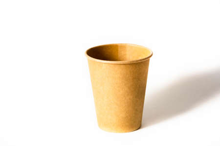 Brown paper cup for coffee, tea, a drink from environmental materials on a white background. One paper cup is on the right and a shadow falls on it on a white background.の写真素材