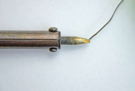 Soldering iron, tin, rosin on a yellow background. Macro. Repair of electrical equipment, radio engineering. Solder wires, contacts. Copy Spaceの写真素材