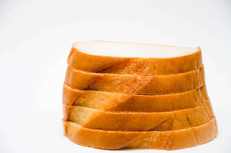 Bread. Long loaf sliced, sliced, sliced on a white background. Bread in macro, stacked on top of one another. Slices of loafの写真素材