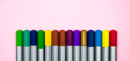 Top of the pencil. Multi-colored pencils in a row on the side and at an angle on a pink background....