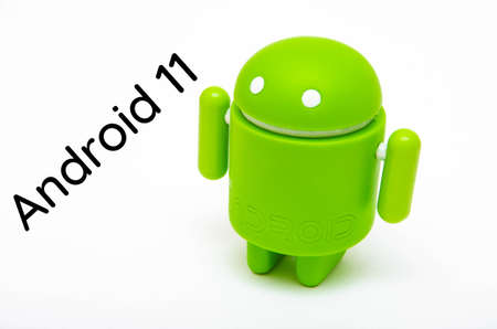 Android figurine. Green android figurine made of ecological plastic on a white background in macro. Android with the inscription android 11のeditorial素材