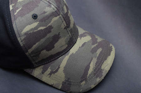 Men's two-tone cap on a black background. The baseball cap is black at the back, front and visor of...