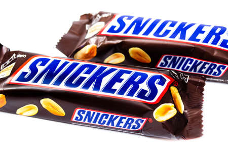 June 2020. Kiev, Ukraine. Two small single bars of snickers of 50 grams lie next to a white background. Top view and side view in macroのeditorial素材