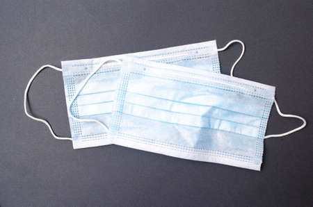 Medical blue mask lies on a black background. Mask close-up and overall plan