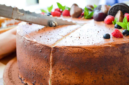 Chocolate cake in cocoa from above berries raspberries, black currant, biscuits, sweets on a round plate on the table. Cake slice, berries in macro. Birthday cake number 2. Top view, side view. Close-upの写真素材