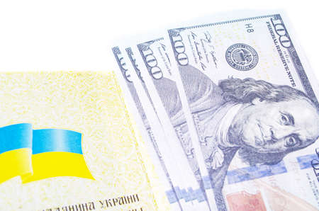 Ukrainian passport on a white background. Dollars of 100 dollars are in the open passport at different angles.の写真素材