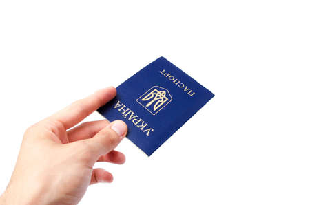 Ukrainian passport on a white background. Man's hand holds a Ukrainian passport in hand, gives the passport. The passport of the citizen of Ukraine in the macro. Passport general plan and close-upの写真素材
