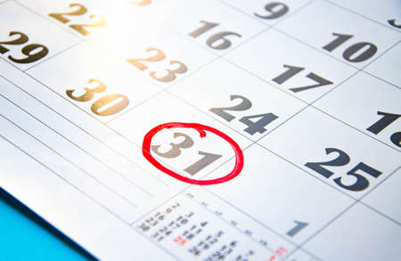 The number 31 in the calendar is circled in red circle on a blue background. A question mark near a number, everything around is dark. Calendar for plans, notes, meetings. Business calendar.の写真素材