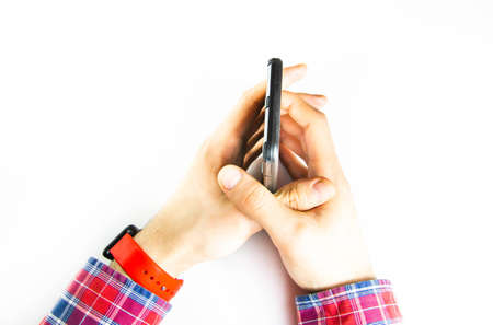 Men's hands in a checkered hipster shirt are holding a smartphone on a white background. The screen is white and black. Hands clutch a smartphone, twist, flip. First-person view. Control Copy spaceの写真素材