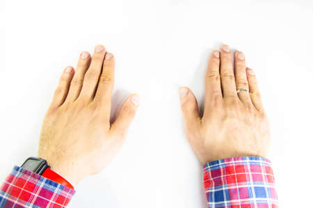 Male hands forearm, on a white table first-person view. Squeeze, hold, consider, demonstrate. Hands that demonstrate, control, dominate, gesticulate. CopySpace Copy spaceの写真素材