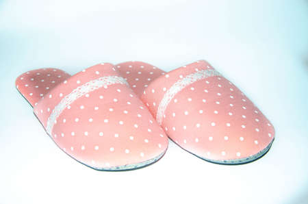 Women's pink warm slippers for the house with white polka dots on a white backgroundの写真素材