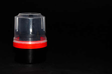 Shoe cream on a black background. Tube flask with a red rim and a paralon counter. Cream for cleaning, grooming, shine. Shoe counter in the hands. Copy spaceの写真素材