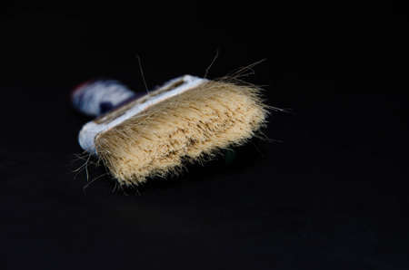 Used paint brush. Blue brush with a red tip in white paint. Macro photo. Repair brush in hand. Fibers copy spaceの写真素材