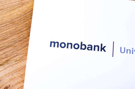 Envelope, packaging, box with under white Monobank debit card on wooden background. Monobank. July, 2020. Kiev, Ukraineのeditorial素材