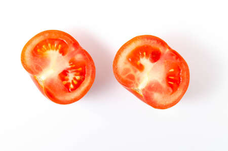 Two red tomatoes in a cut on a white background front and top view.の写真素材
